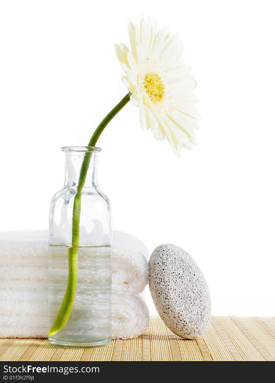 Flower, towels, and pumice stone against a white background. Flower, towels, and pumice stone against a white background.