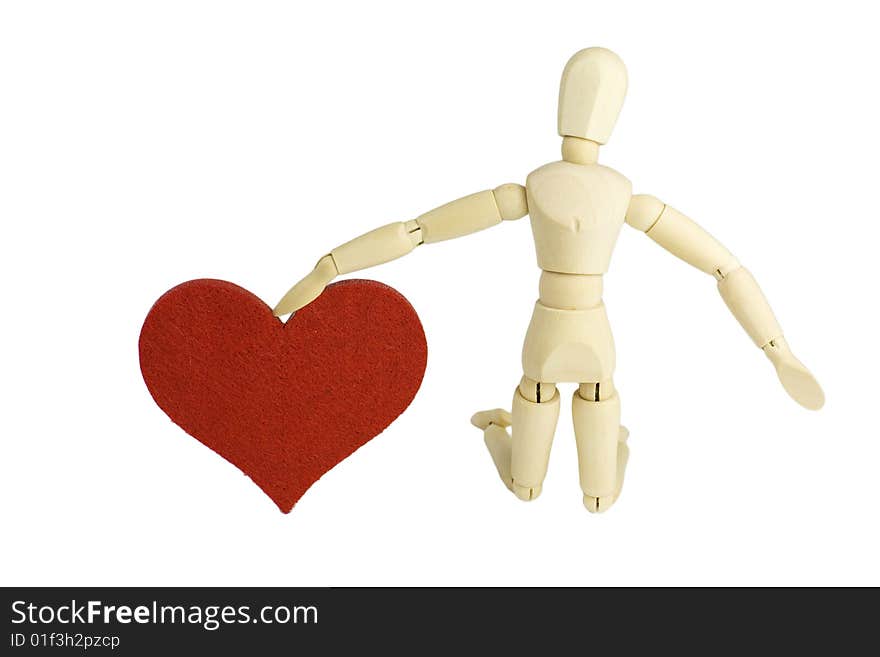 A wooden dummy figurine kneeling down and offering his love - a big red heart in an engagement proposal gesture. A wooden dummy figurine kneeling down and offering his love - a big red heart in an engagement proposal gesture.