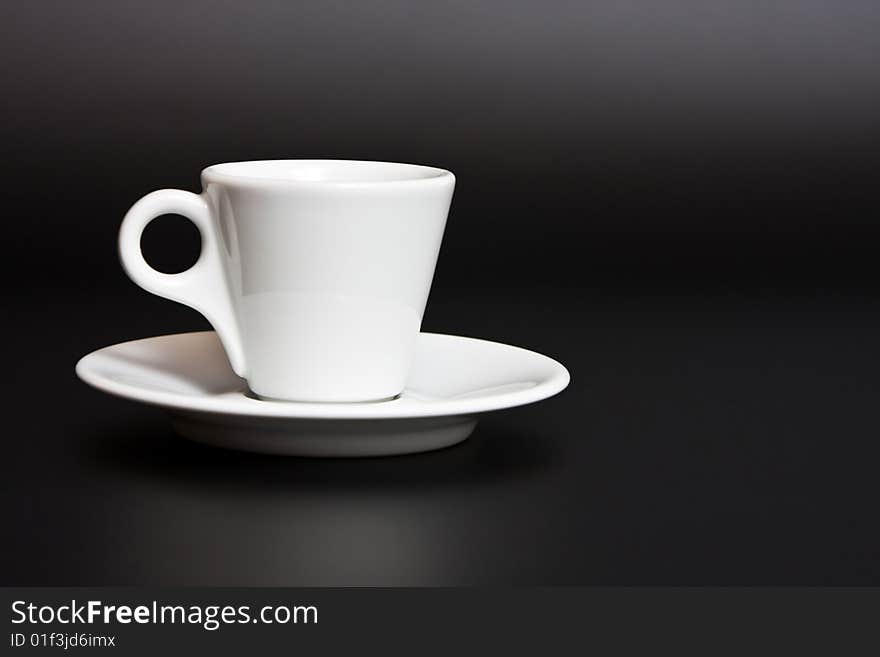 White coffee cup and saucer on a black background. White coffee cup and saucer on a black background.