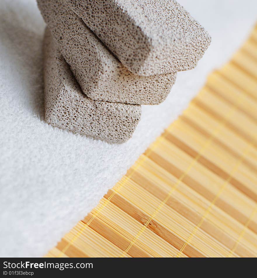 Pumice stones and towel against bamboo reed mat. Pumice stones and towel against bamboo reed mat.