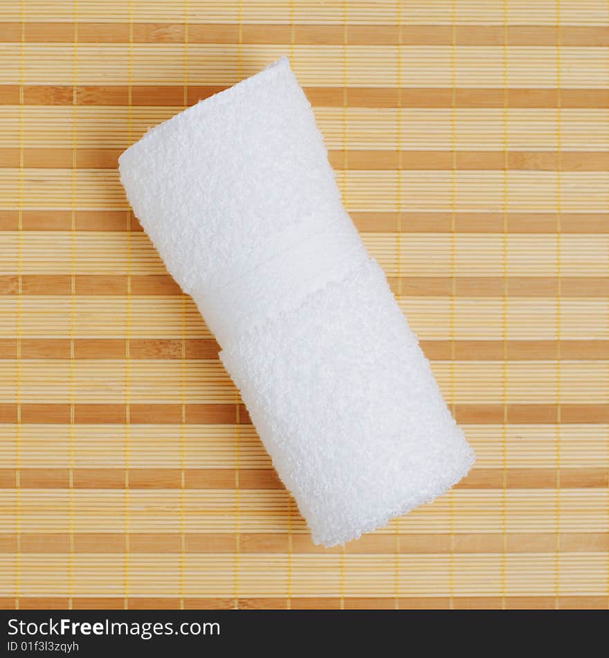 White towel against bamboo reed mat background. White towel against bamboo reed mat background.