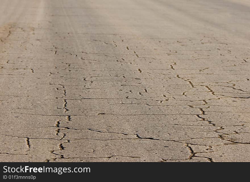 View of cracked asphalt road.