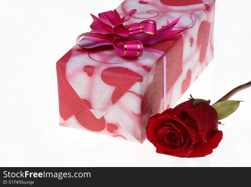 Beautiful gift box and a rose are on white background.