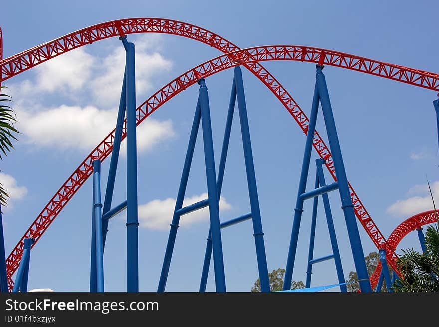 Colorful roller coaster tracks against blue sky. Colorful roller coaster tracks against blue sky