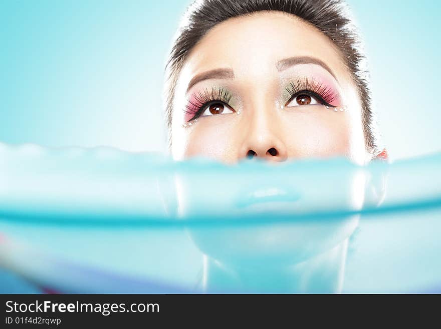 Stunning female face peeking from above blue silk. Stunning female face peeking from above blue silk