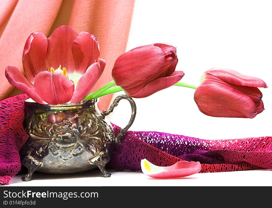 Red flowers in vase with fabric