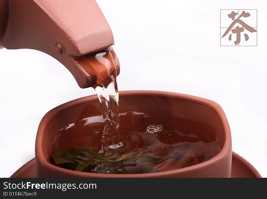 Green tea pouring into tea cup from teapot on white background. Chinese on the picture is tea. Green tea pouring into tea cup from teapot on white background. Chinese on the picture is tea.