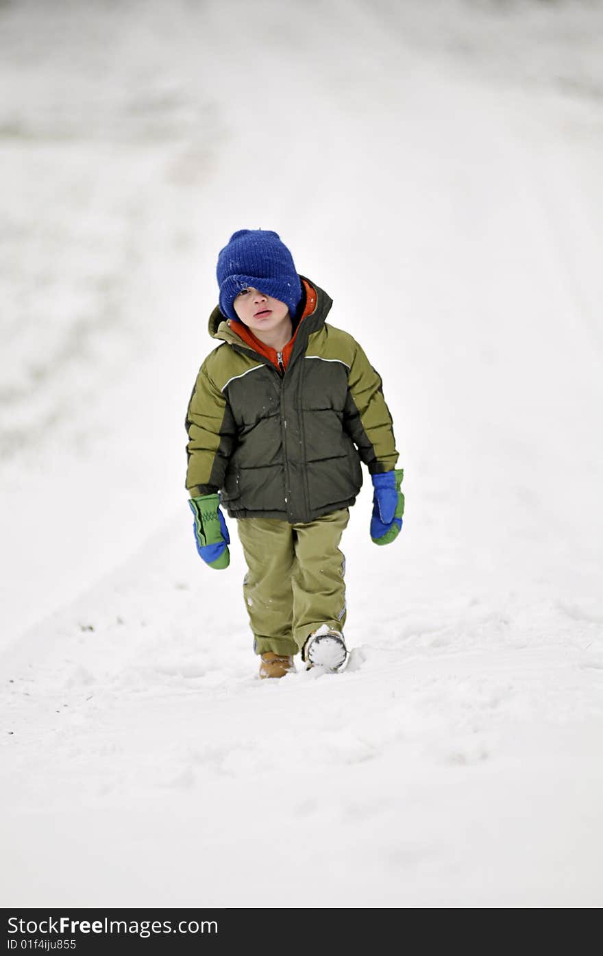 Little boy walking in snow