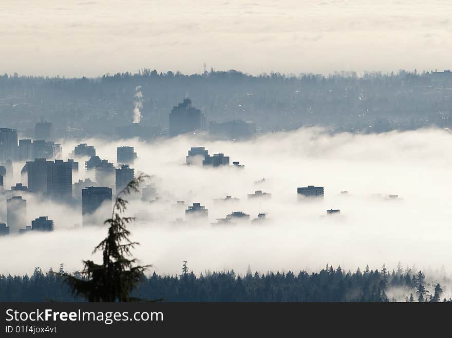 Buildings above the clouds. This view is from a mountain looking west. Buildings above the clouds. This view is from a mountain looking west.