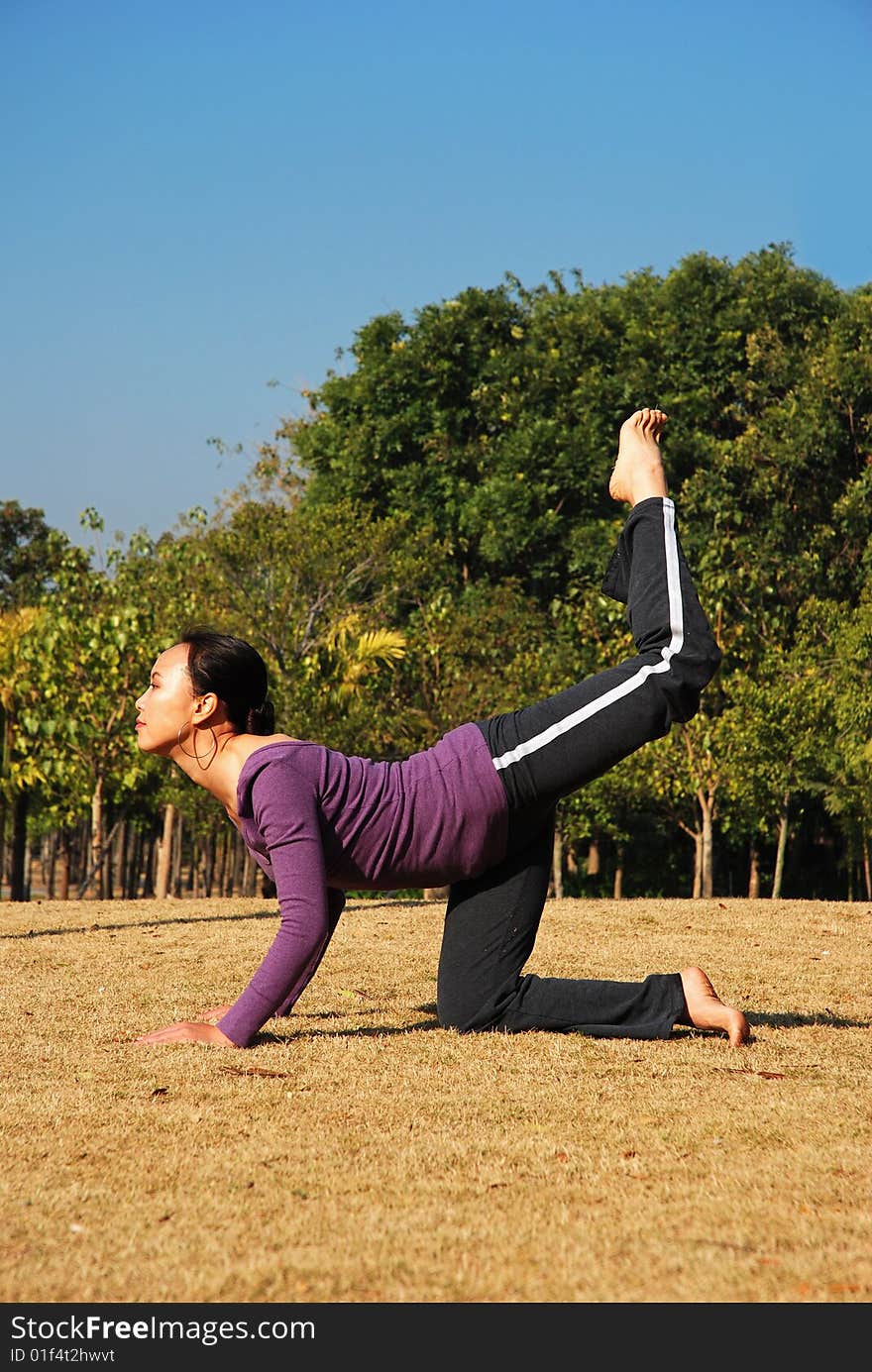 Young Asian Woman exercising Yoga in the park