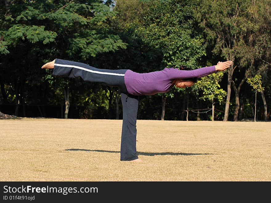 Young Asian Woman exercising Yoga in the park