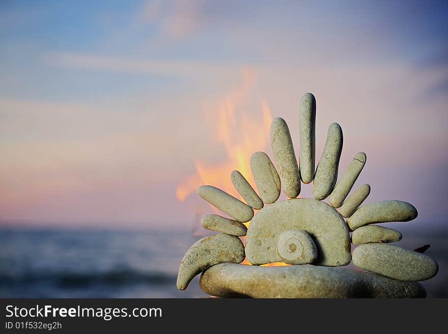 The stone sun burns on a beach in the summer evening. The stone sun burns on a beach in the summer evening