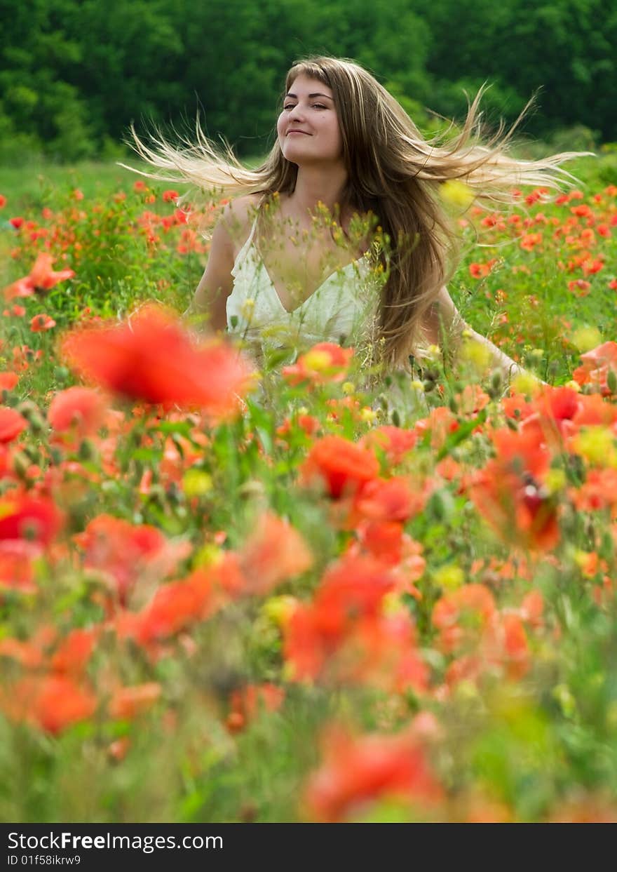 Young girl with long hair in poppies field