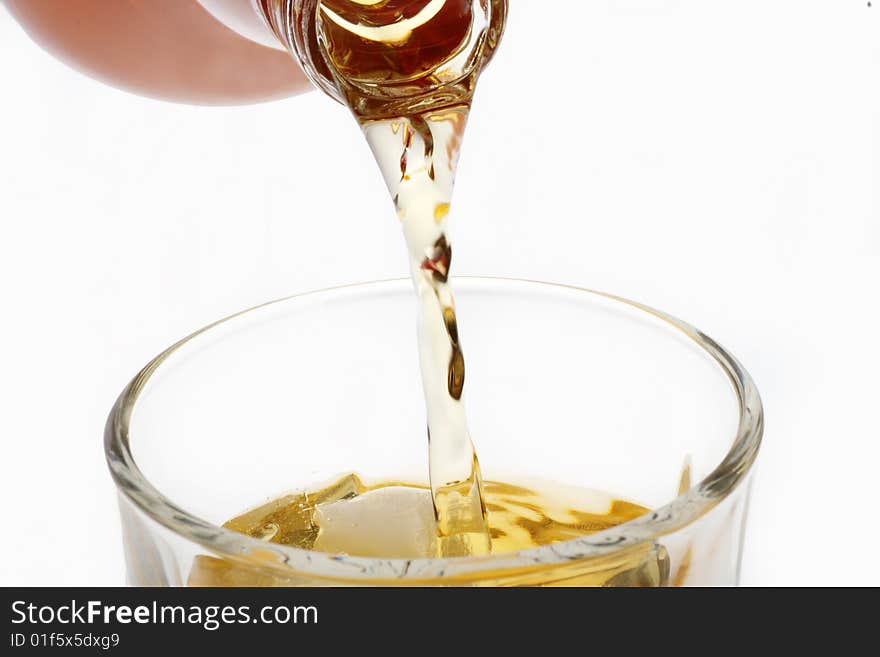 Pouring whisky in a glass on white background. Pouring whisky in a glass on white background.