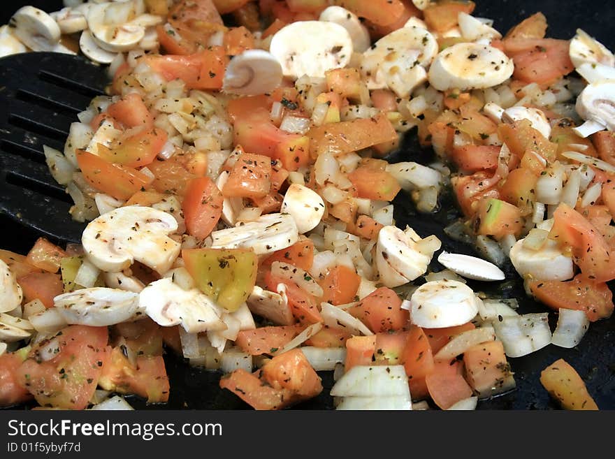 Mushrooms, Onions and tomatoes being stir fried