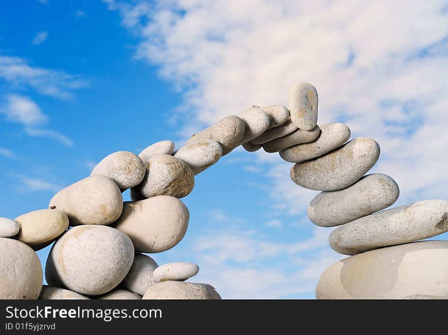 Sea pebble combined in the form of the bridge against the sky. Sea pebble combined in the form of the bridge against the sky