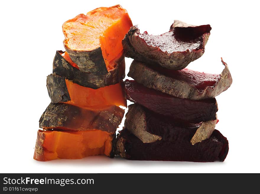 Grilled beet and carrot cut into pieces and stacked in a pile. Isolated on a white background. Grilled beet and carrot cut into pieces and stacked in a pile. Isolated on a white background.