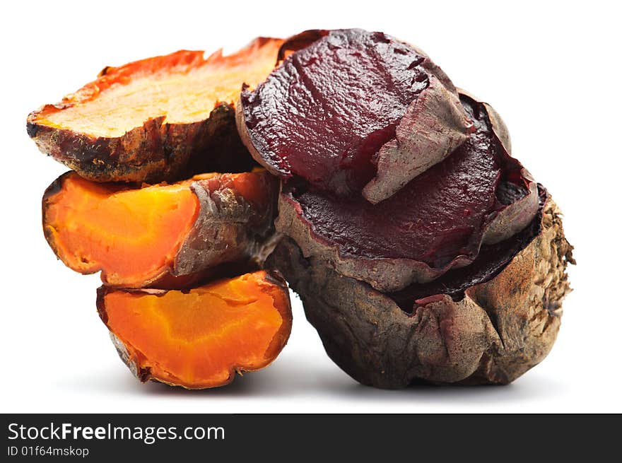 Grilled beet and carrot cut into pieces and stacked in a pile. Isolated on a white background.