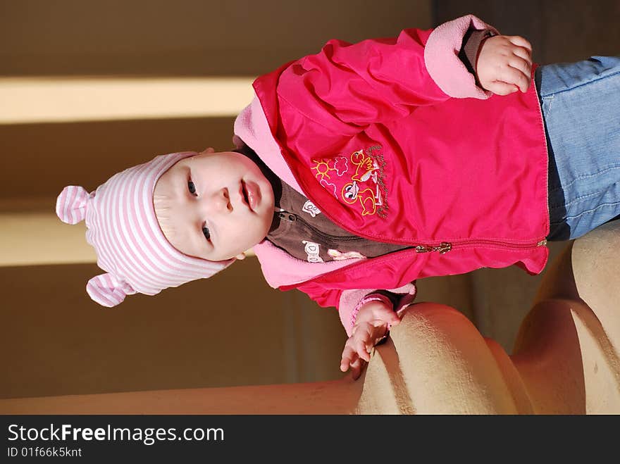 Little girl in a brightly red jacket near a column. Little girl in a brightly red jacket near a column