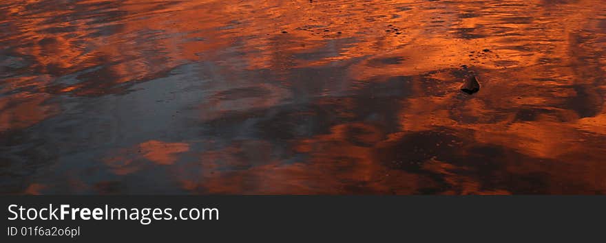 Orange glow of sunset reflected on water. Orange glow of sunset reflected on water