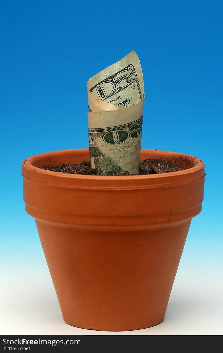 $20.00 US bill sprouting in terra cotta flower pot on graded blue/white background. $20.00 US bill sprouting in terra cotta flower pot on graded blue/white background.