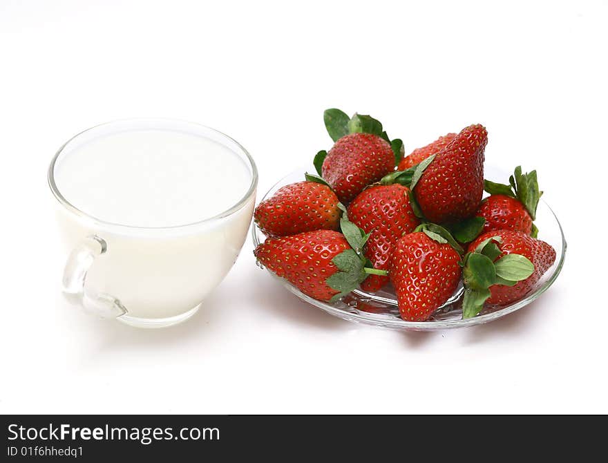 Glass cup with milk and a strawberry. A still-life on a white background. Glass cup with milk and a strawberry. A still-life on a white background.