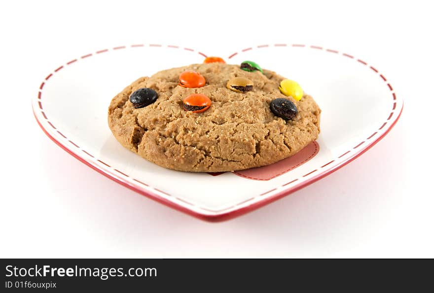 Cookie on heart shaped plate with shallow depth of field and isolated background.