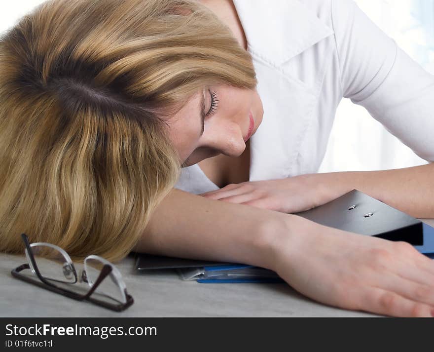 The girl sleeps on folders for papers. The girl sleeps on folders for papers