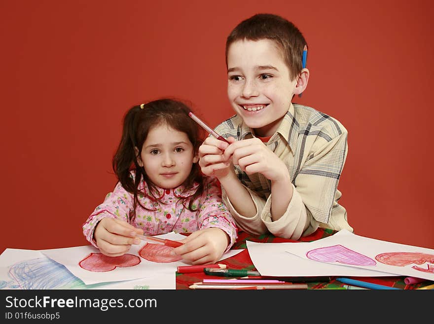 Sister and brother togetherness, children collectively drawing valentine hearts