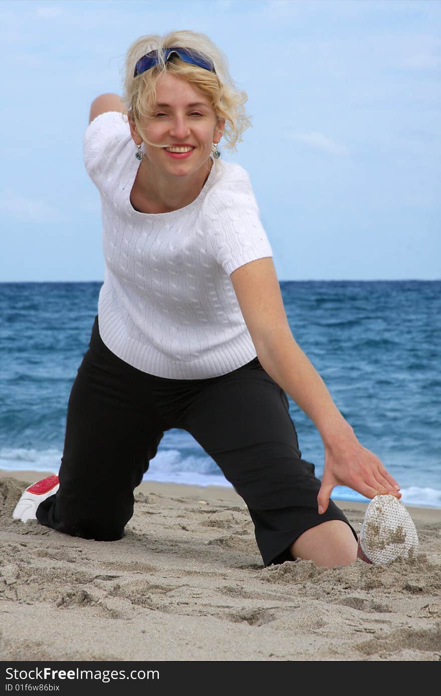 Blond girl exercising at sea beach