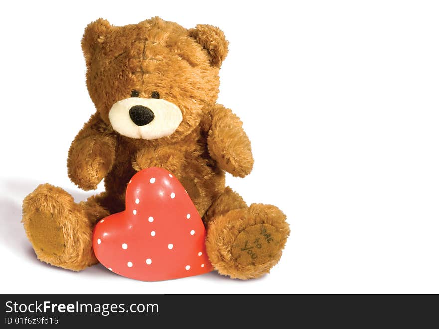 Brown teddy bear with red heart isolated on white background