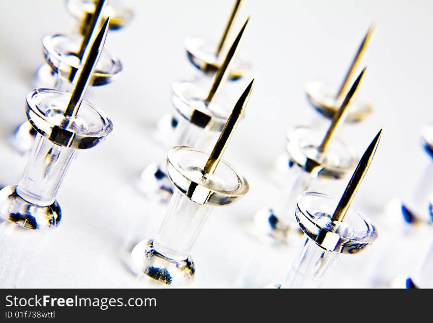 Macro photograph of thumbtacks on white