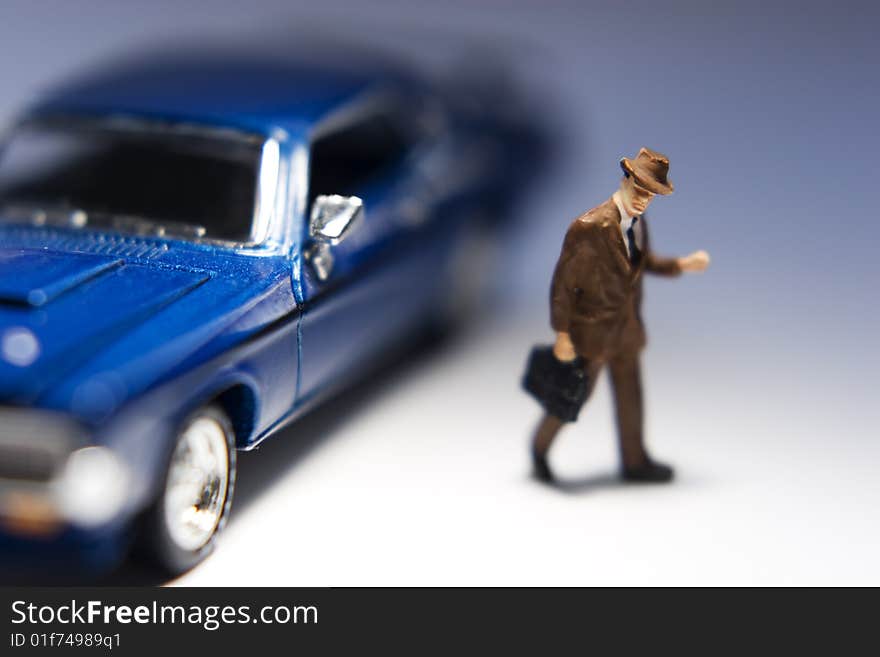 Businessman figurine with briefcase leaving a blue car. Businessman figurine with briefcase leaving a blue car