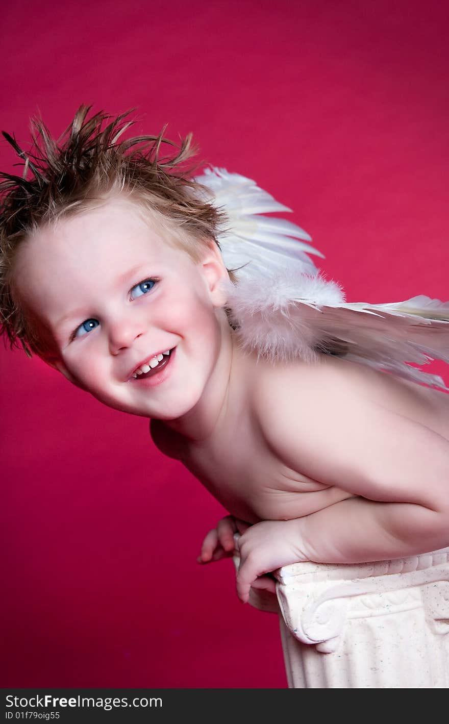 Little Laughing Angel leaning on decorative pillar. Little Laughing Angel leaning on decorative pillar