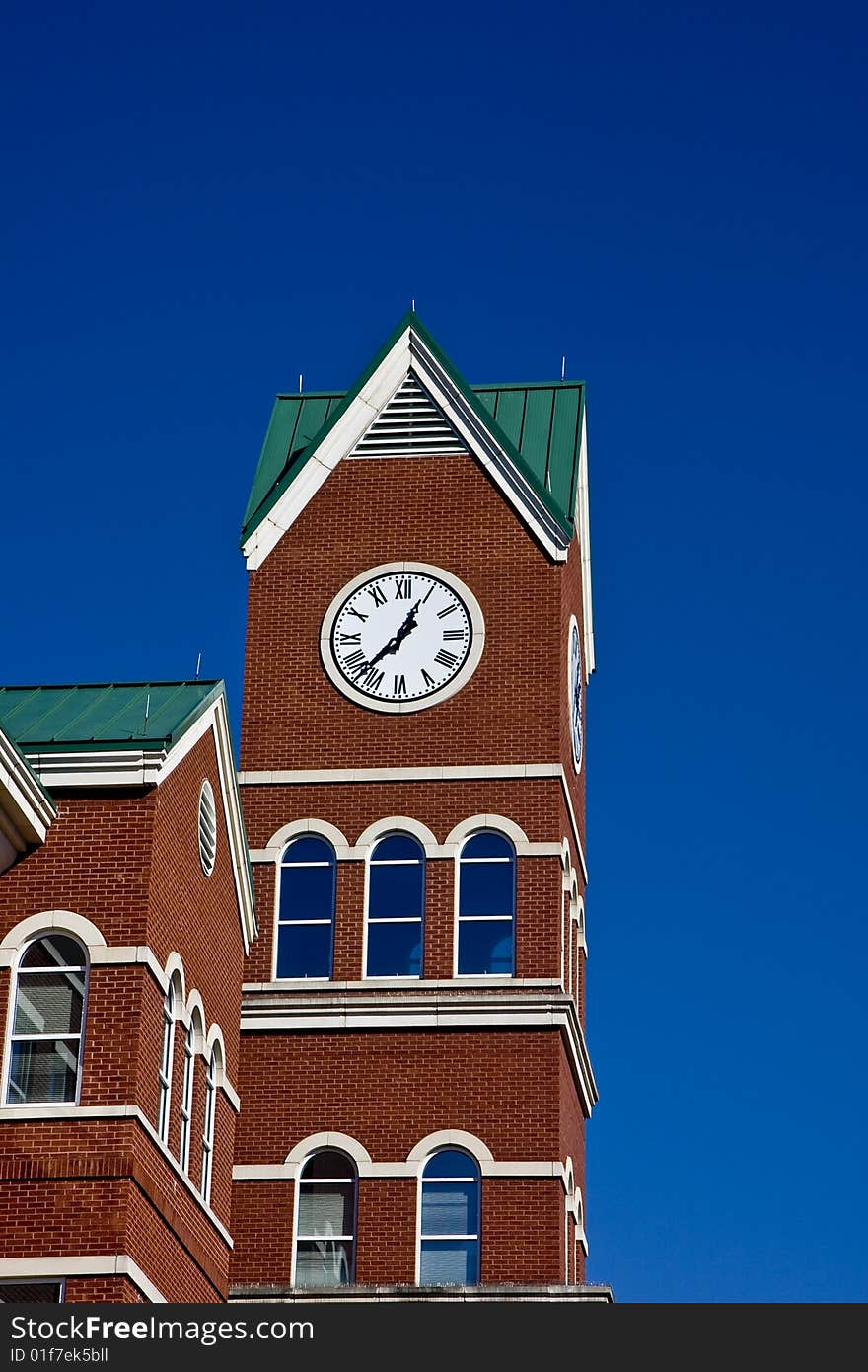 A clock on a brick building against a blue sky. A clock on a brick building against a blue sky