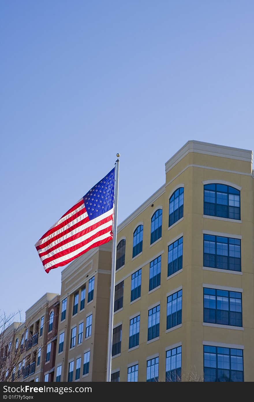 A high rise yellow stucco condo with an American flag against a blue sky. A high rise yellow stucco condo with an American flag against a blue sky