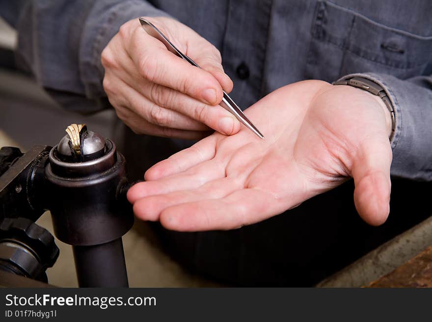 Goldsmith work in process. The goldsmith put a stone into the ring.