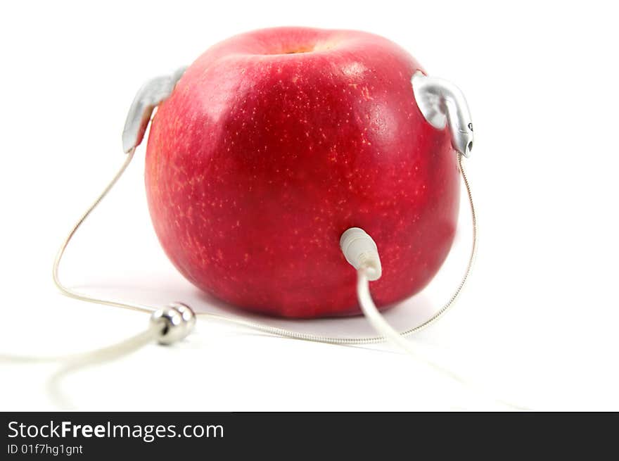 Red apple with earphones like player isolated on white. Red apple with earphones like player isolated on white