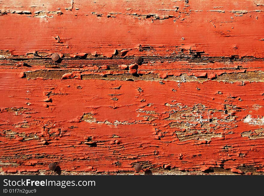 Red painted cracked wooden plank with rusty tacks. Red painted cracked wooden plank with rusty tacks