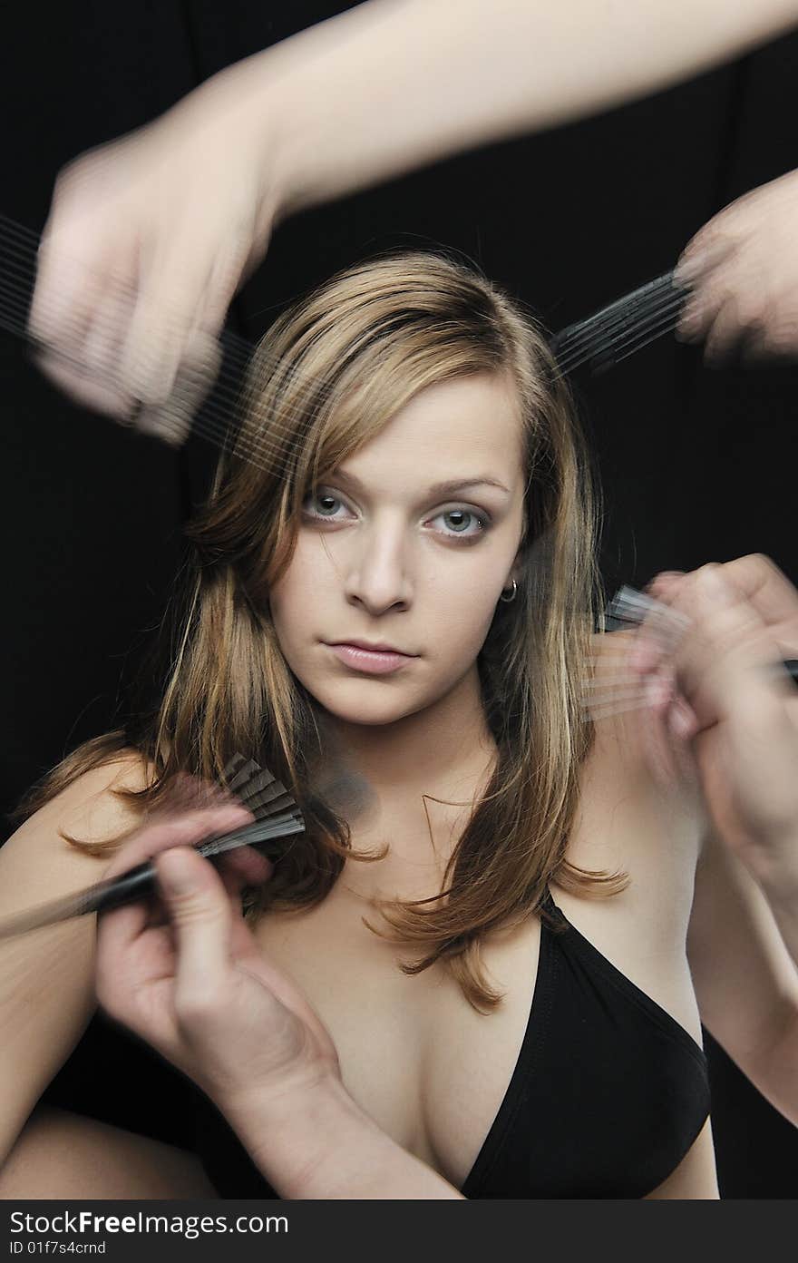 Two Makeup artist help girl getting her make-up