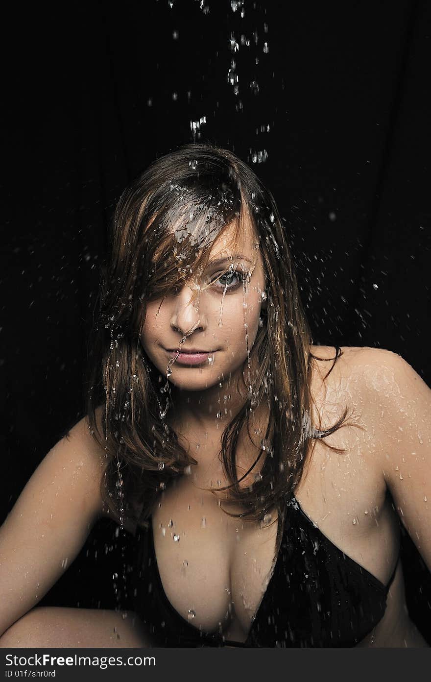 Portrait of woman taking a shower on black background. Portrait of woman taking a shower on black background