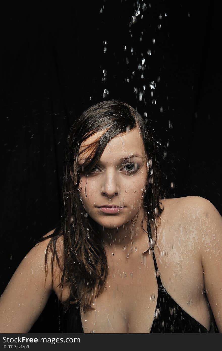 Portrait of woman taking a shower on black background. Portrait of woman taking a shower on black background