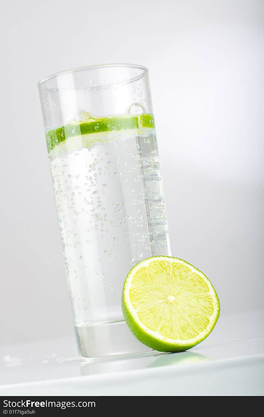 Glass with mineral water and limes, shot in studio