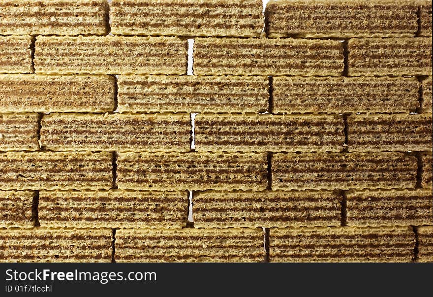 Food background texture - chocolate wafers arranged in rows, forming a sweet wall obstacle - sugar addiction.