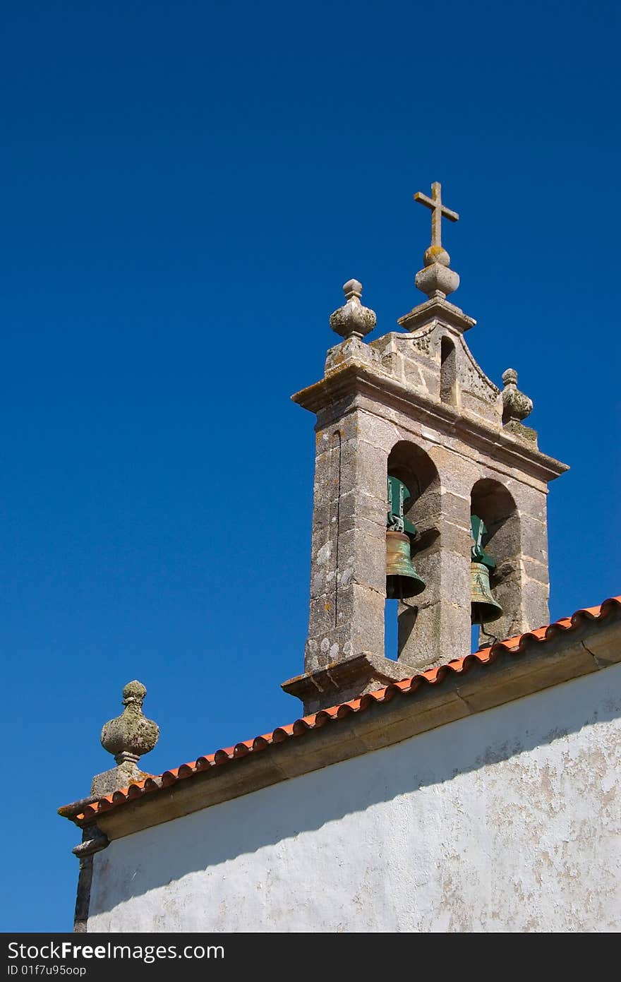 Detail of a Spanish bell tower with two bells against clear blue sky. Detail of a Spanish bell tower with two bells against clear blue sky.