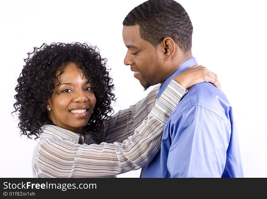 A professional couple hugs eachother in front of a white background. A professional couple hugs eachother in front of a white background