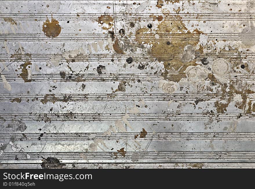 A stained and paint splotched metal sheet background. A stained and paint splotched metal sheet background