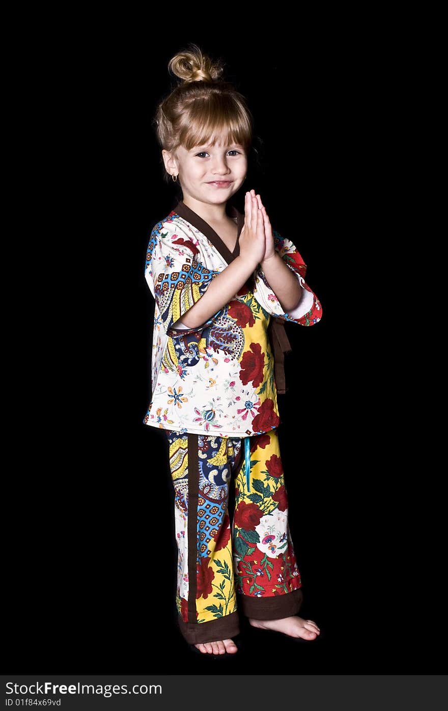 Little girl posing with a kimono over a black background. Little girl posing with a kimono over a black background