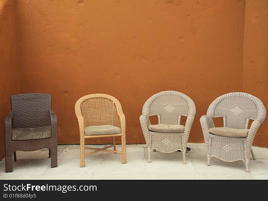 4 multiple wicker straw adirondack chairs against colorful bright background patio garden. 4 multiple wicker straw adirondack chairs against colorful bright background patio garden