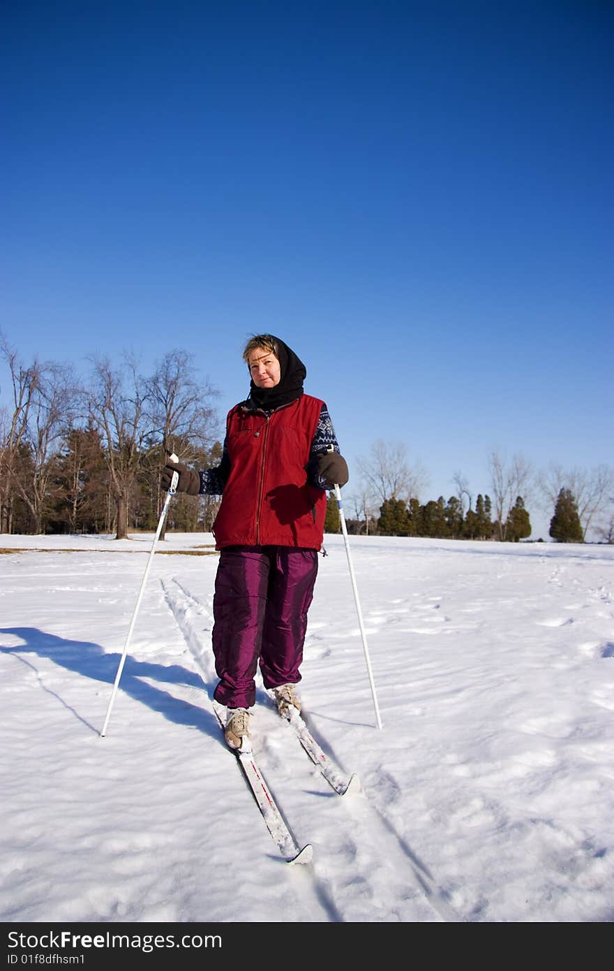 A Woman Cross Country Skiing Accross An Open Field